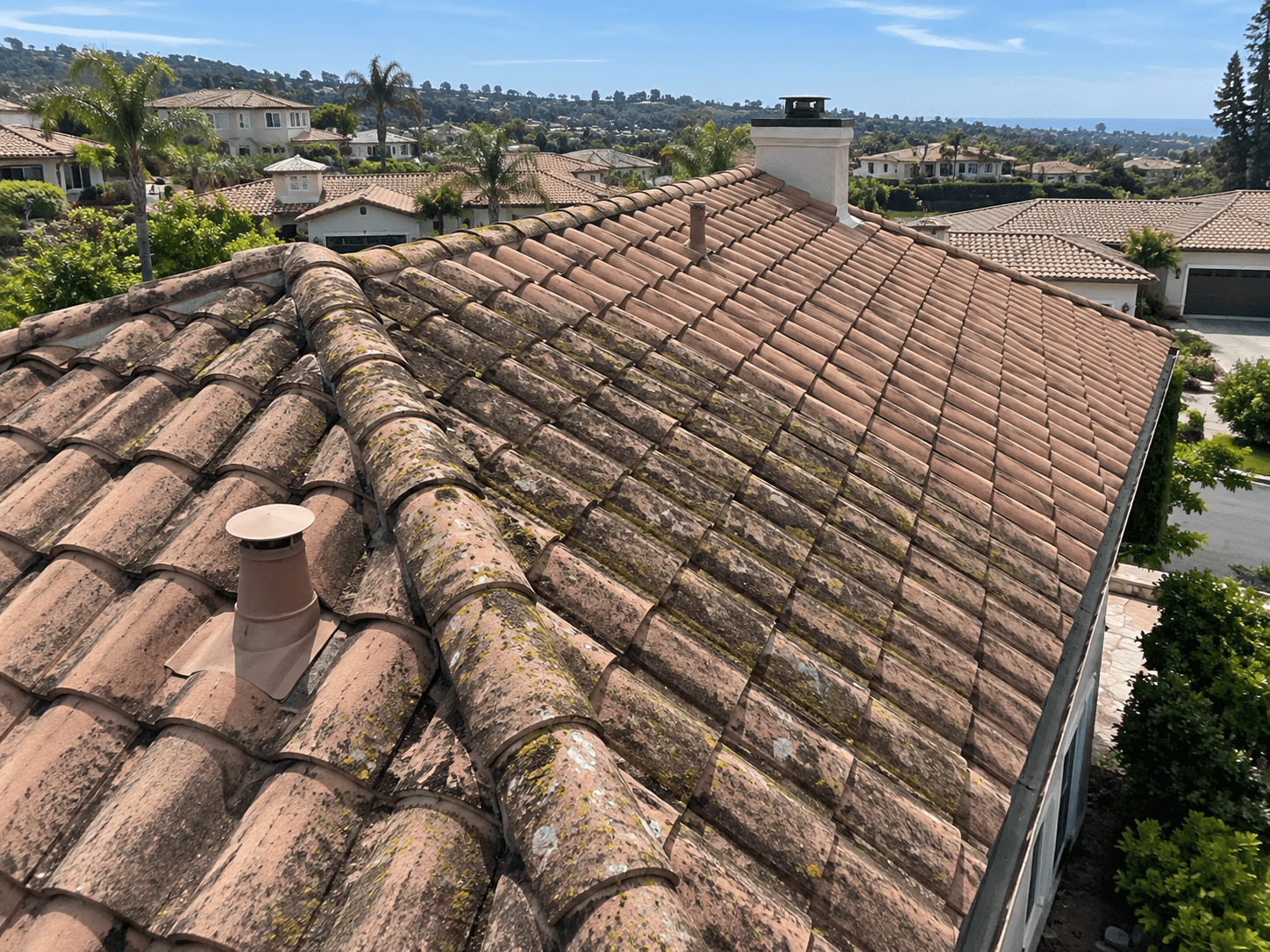 The same tile roof before WashCraft soft-wash service, with algae and moss buildup